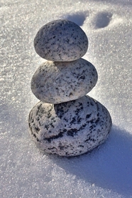 白色雪地堆叠的石块图片