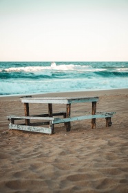海滩上的棕色木制长凳图片