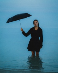 站在海水中撑伞的美女图片