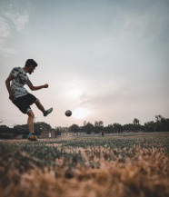 运动员草地踢足球图片