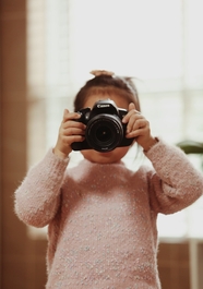小女孩手持相机拍照图片