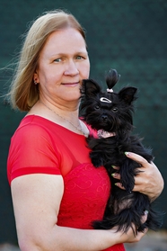 抱着黑色狗狗的中年女人图片