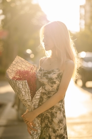 街头逆光街拍美女手捧花图片