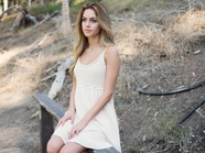 坐在岩石山的白色连衣裙美女图片