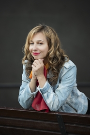 手撑着下巴甜甜微笑的卷发美女图片