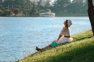 美女坐在河边草地呼吸新鲜空气图片