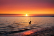 日暮黄昏海上搁浅的小舟图片