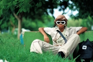 坐在草地上的戴墨镜男孩图片