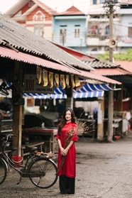 越南少女穿着红色旗袍站在街头图片