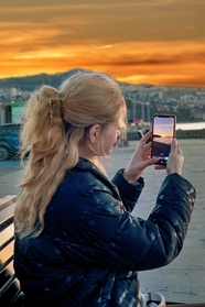 欧美美女用手机拍黄昏美景图片