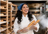 手持法棍面包的美女烘焙师图片