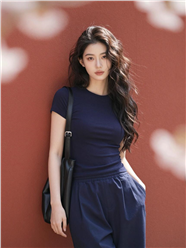 站在红棕色墙壁前的长卷发美女图片